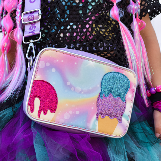 A close up of a girl wearing a purple crossbody bag with a colourful ice cream front cover.
