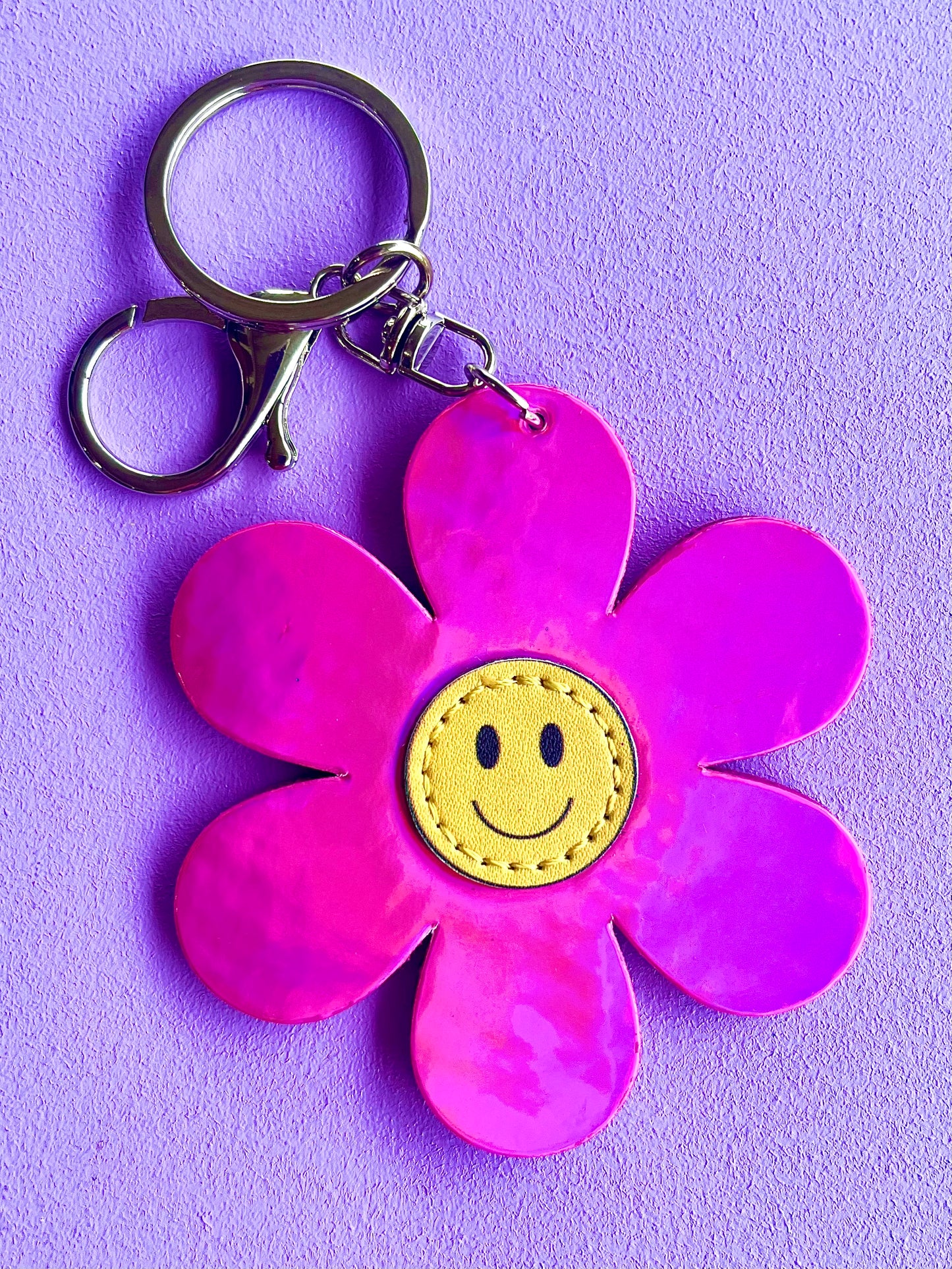 Pink smiley flower bag charm from Popsy & Co. It has a silver-like clasp.