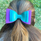 Aqua and purple hair bow in girls hair.