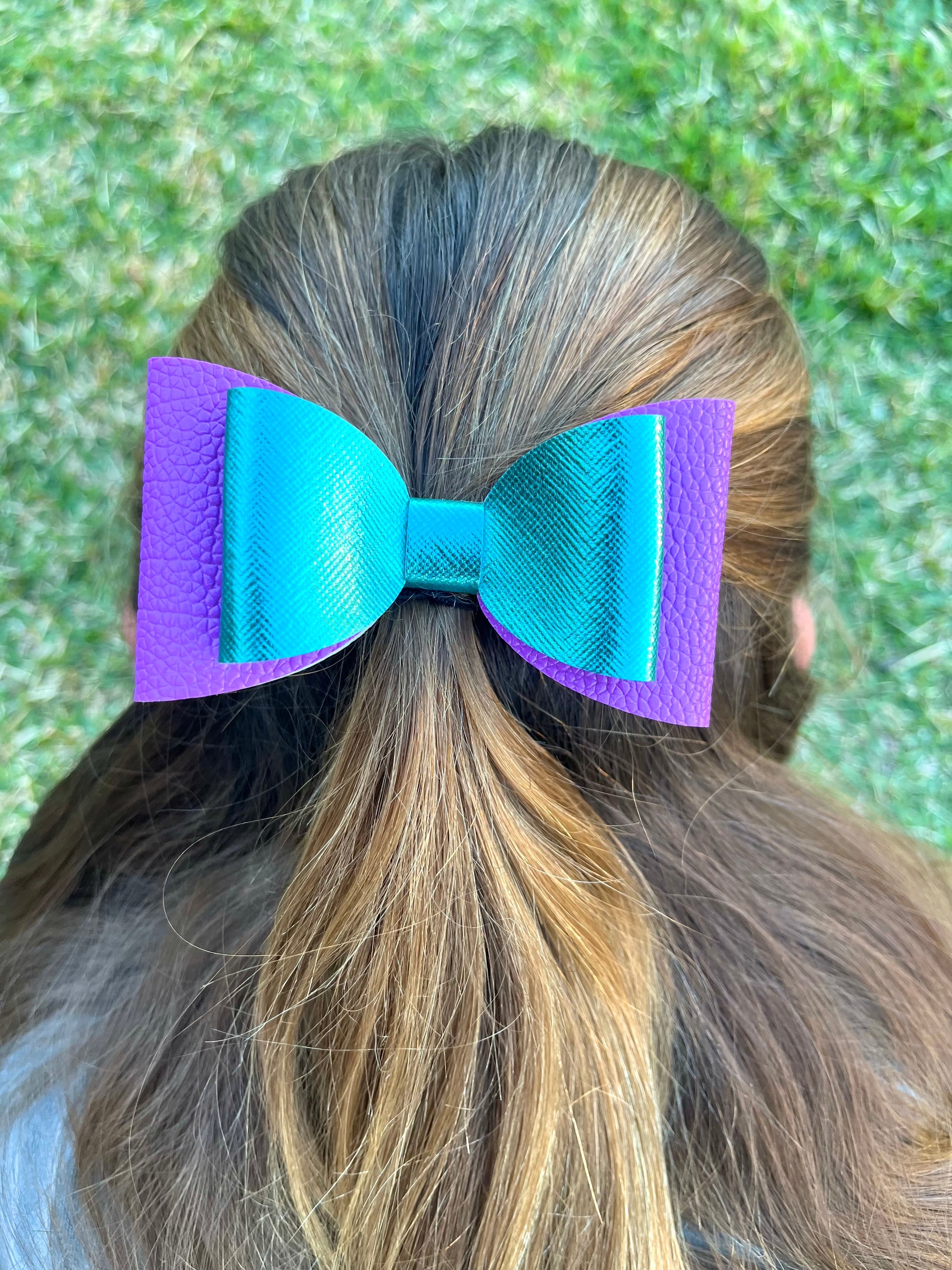 Aqua and purple hair bow in girls hair.