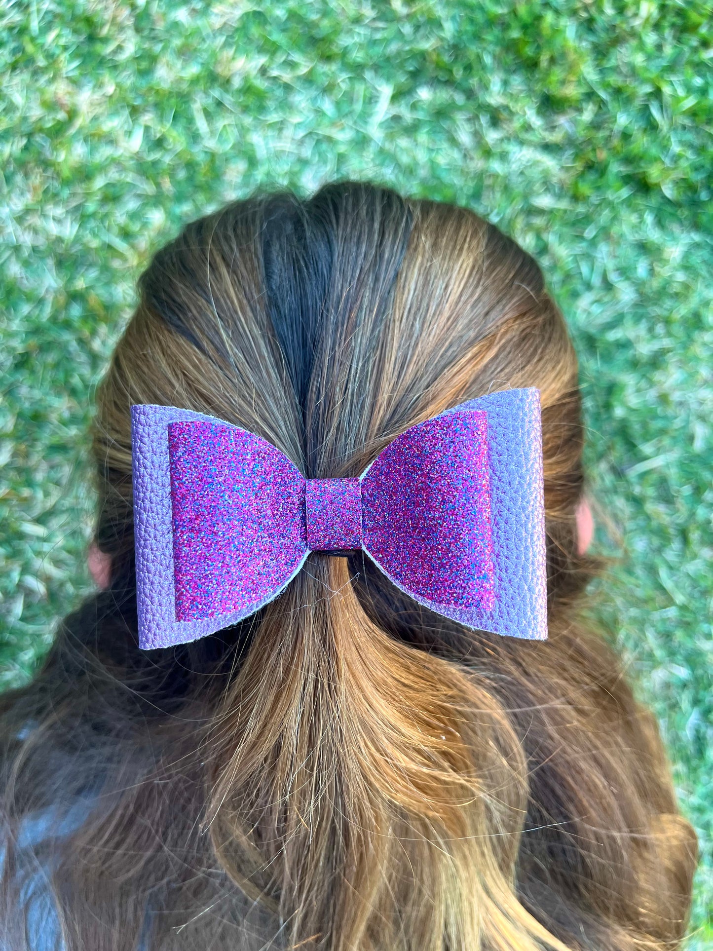 Purple glitter hair bow in girls hair.