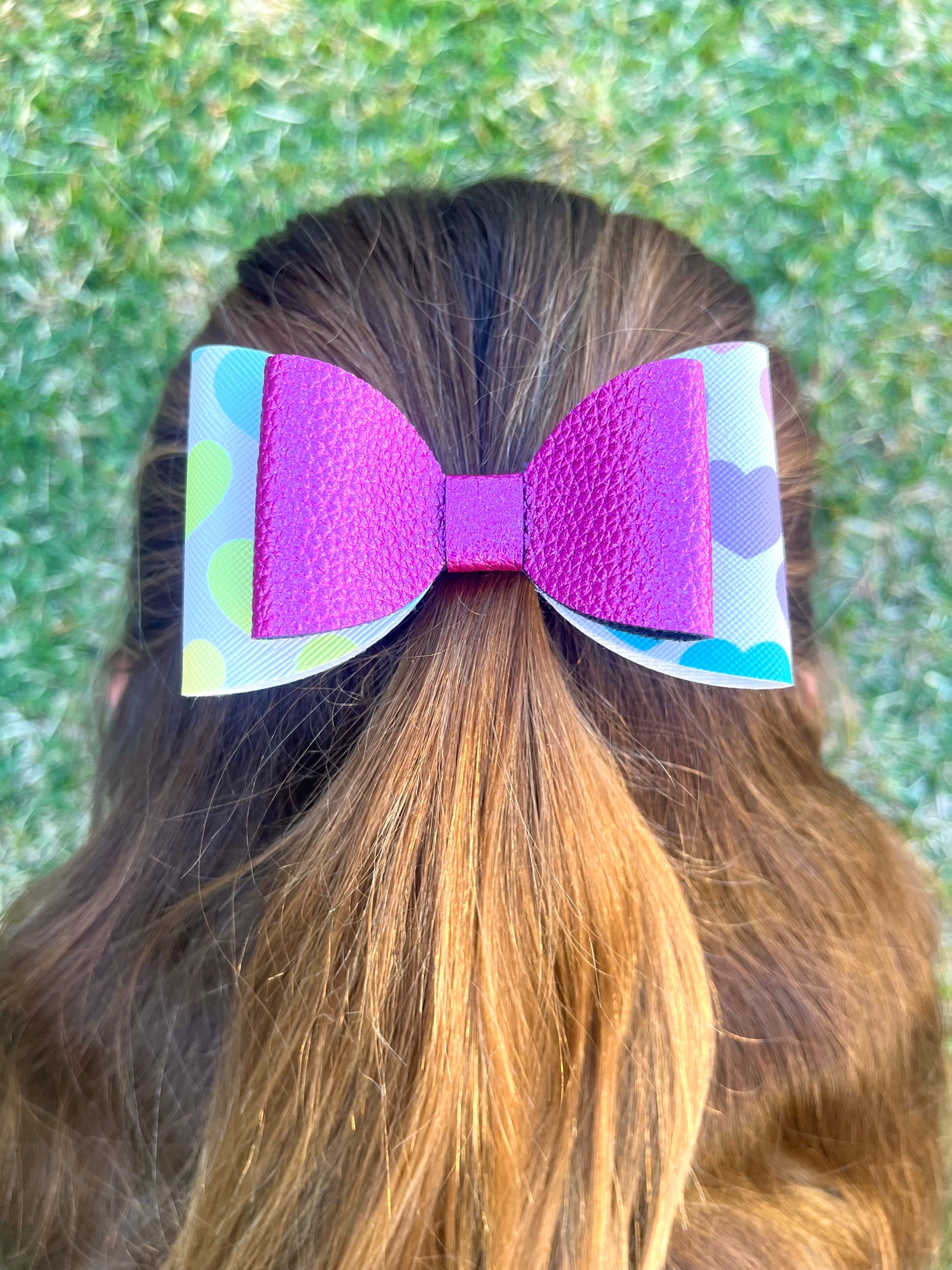 Pink and hearts hair bow in girls hair.