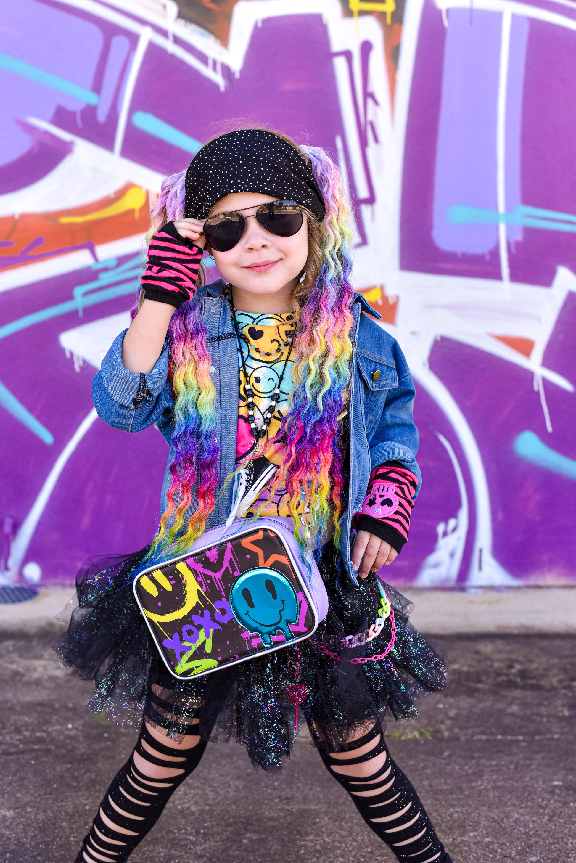 Girl wearing the graffiti smiles popsy bag