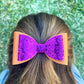 Orange and pink glitter hair bow in girls hair.