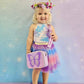 Girl wearing a kids purple crossbody bag with the butterfly wishes interchangeable cover from Popsy and Co.