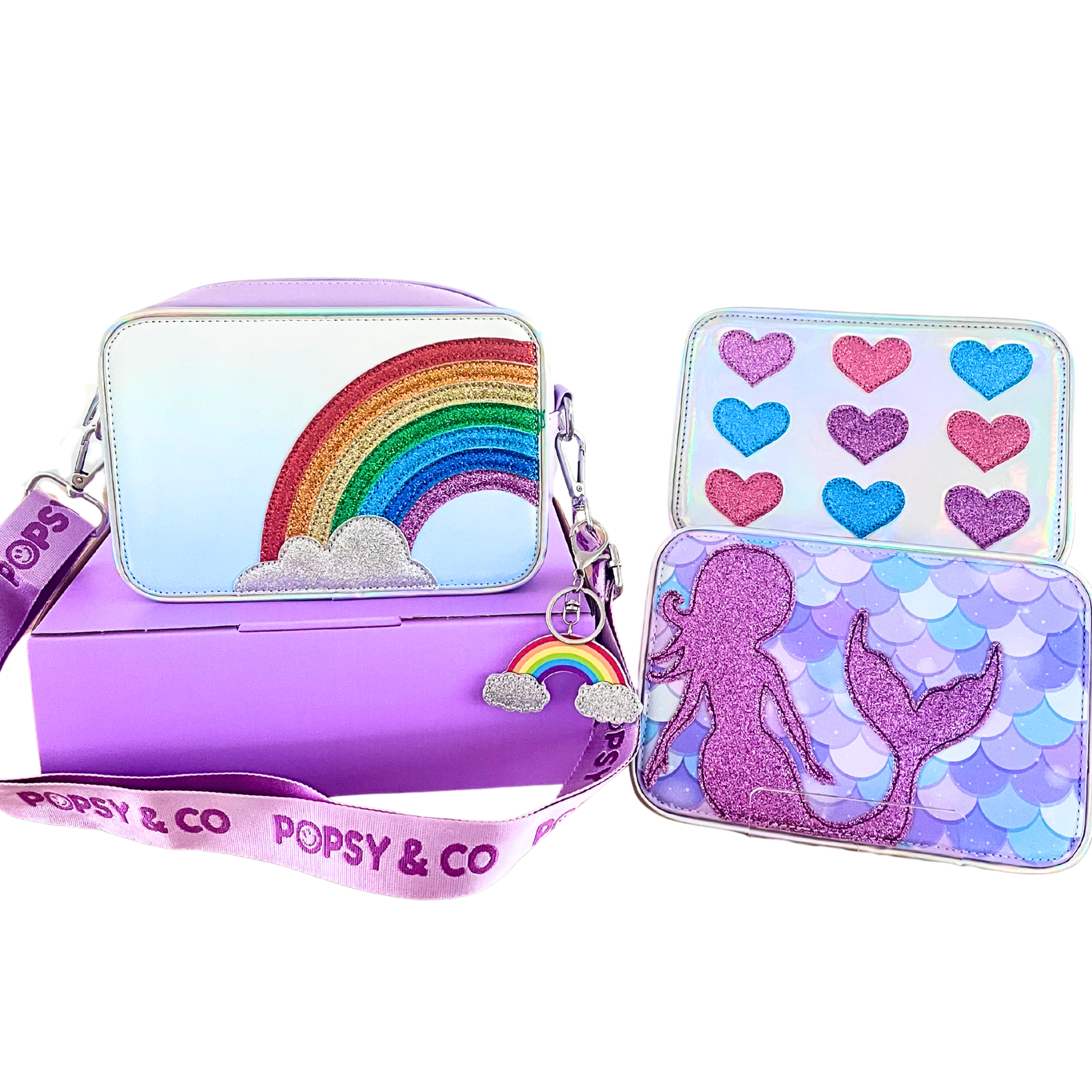 Magic Deluxe Gift displaying purple bag with rainbow cover, mermaid interchangeable cover, glitter hearts interchangeable cover and rainbow bag charm.