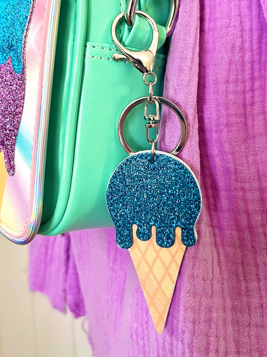 Blue glitter icecream bag charm. It is clipped onto a Popsy & Co crossbody bag with a silver-like clip.