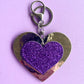 Purple glitter heart keyring accessory for kids. It has a silver metallic background and silver-like clip.