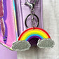 Rainbow keychain with silver glitter clouds for kids. It has silver-like hardware to attach to bags.