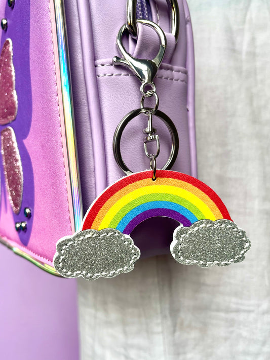 Rainbow keychain with silver glitter clouds for kids. It has silver-like hardware to attach to bags.